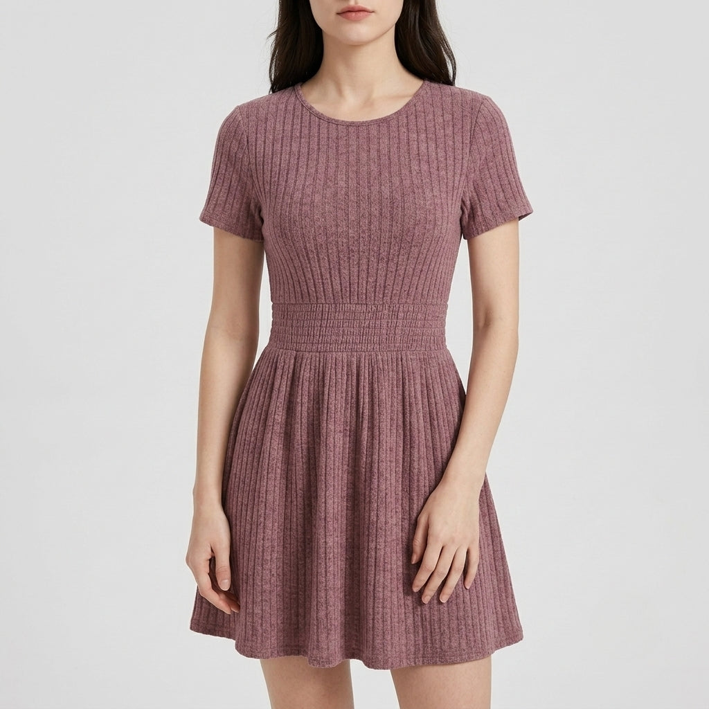 A woman wearing a short-sleeve, ribbed knit fit-and-flare dress in mauve color, photographed against a plain light gray studio background.