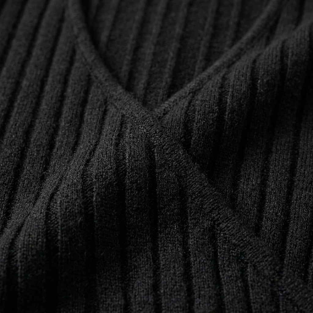 Close-up of a black ribbed knit sweater showing the texture and V-neckline detail.