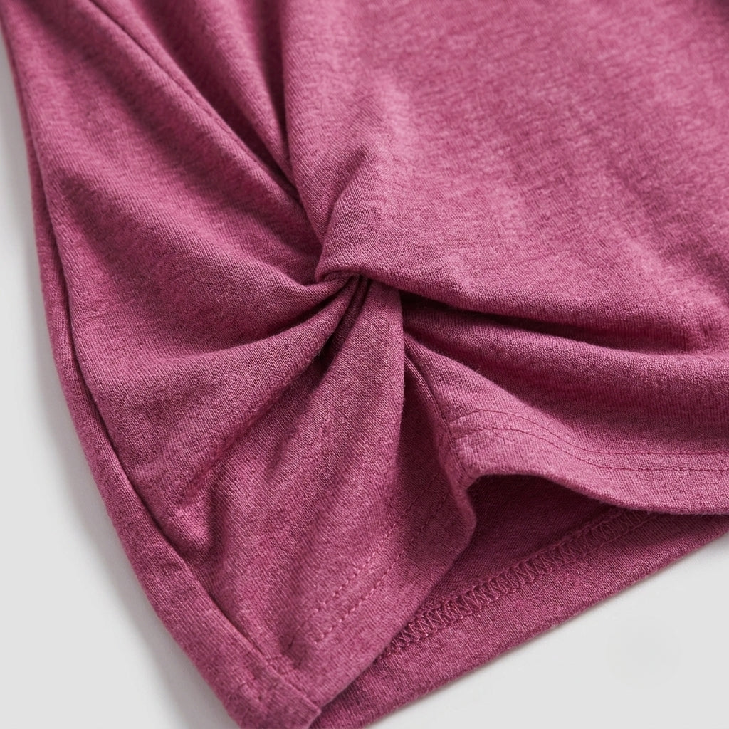 A close-up of a heathered dusty rose pink fabric, showing a gathered texture and a folded hem on a light gray background.