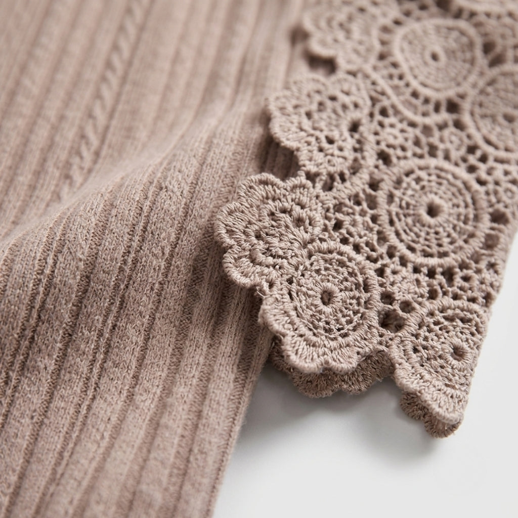 Close-up of a ribbed knit fabric in a muted taupe-brown color, featuring a decorative scalloped crochet lace trim along the edge.